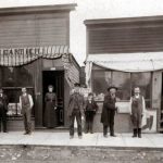 Around 1902, Fred Cartier and friends enjoy a new cement sidewalk near Clinton Street where East Park is today. Fred, in shirtsleeves and vest, was a master tailor and proprietor of a fine haberdashery. To the right is Jimmy Conner, in white shirtsleeves and apron, the short-tempered owner of the shoe repair shop. At far right, holding a boot in each hand, stands three-hundred-pound Charlie Jeffries who owned a butcher shop up the street and served a few terms as Charlevoix’s monumental chief of police. 1902 New Cement Sidewalk